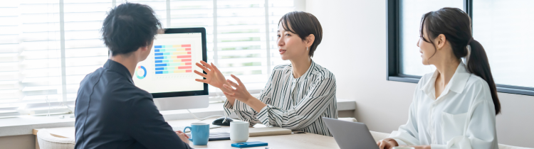 オフィスで3人の社員が会議する様子
